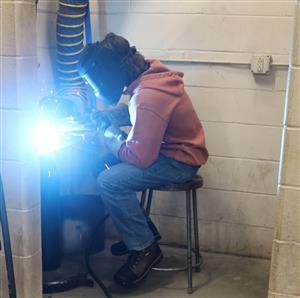 a Metal Trades student practices in the weld booth. 